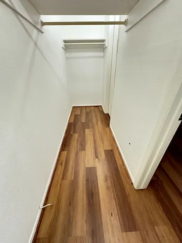 a view of a hallway with wooden floor