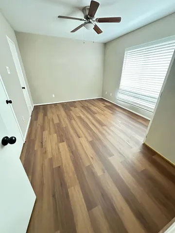 wooden floor in an empty room with a window