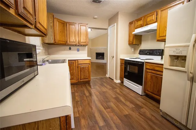 a kitchen with a sink cabinets stainless steel appliances and a window