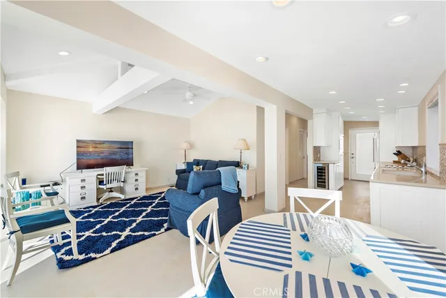 a large white kitchen with a sink and breakfast area