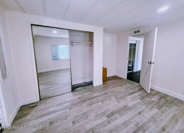 a view of empty room with wooden floor