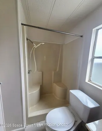 a bathroom with a toilet and a shower