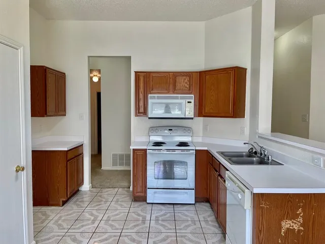 a kitchen with stainless steel appliances granite countertop a sink and a stove