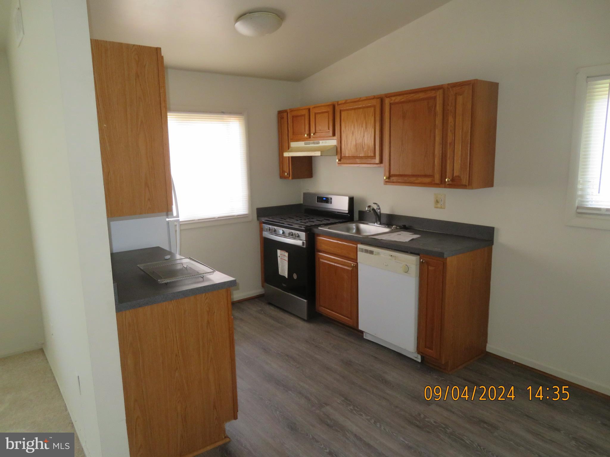 100 9th Street, Unit 305 Laurel, MD 20707 - Photo 2 of 7 a kitchen with stainless steel appliances granite countertop a sink and a stove top oven