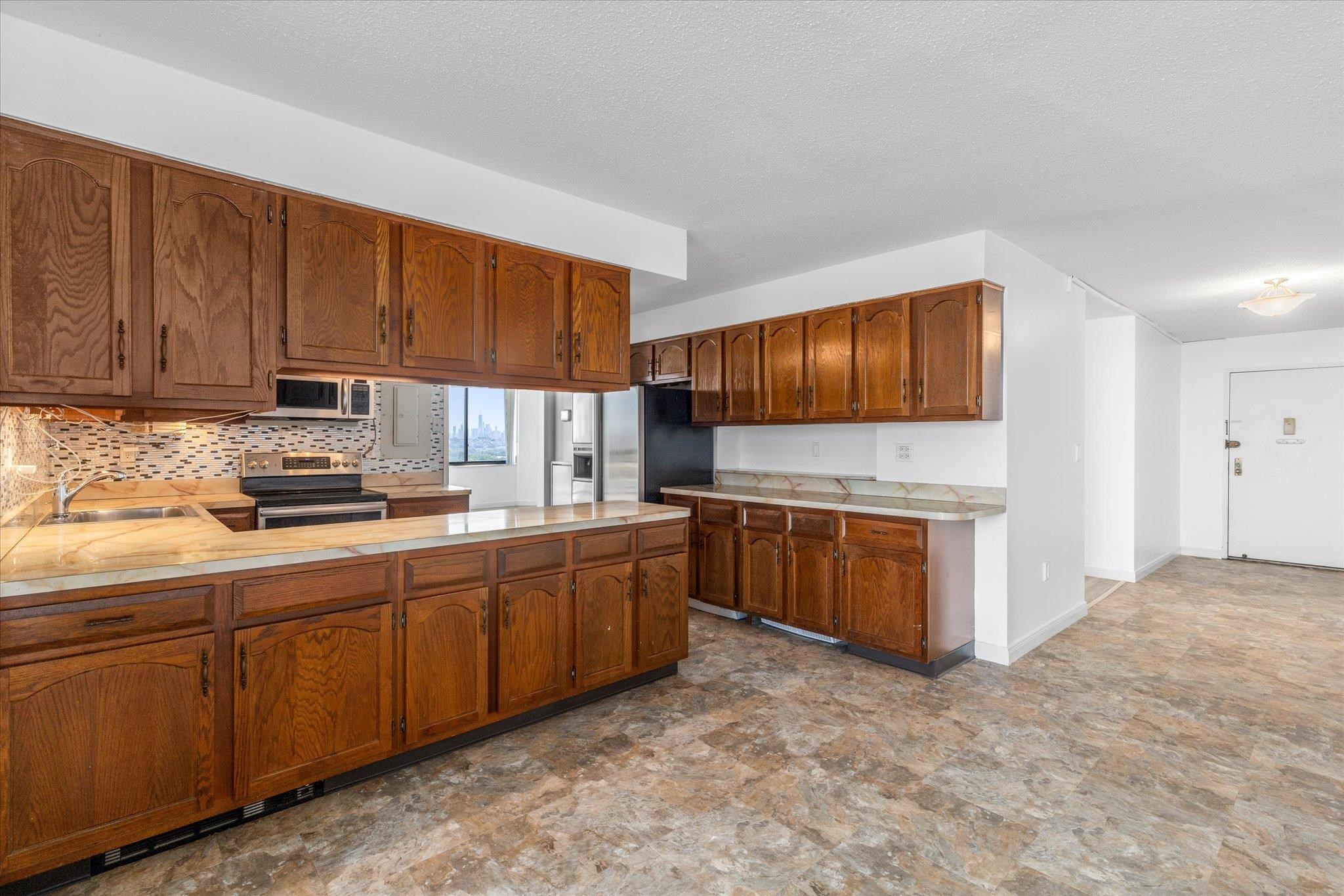 1705 Harmon Cove Tower, Unit 1705 Secaucus, NJ 07094 - Photo 6 of 49 a kitchen with stainless steel appliances granite countertop a stove sink and cabinets