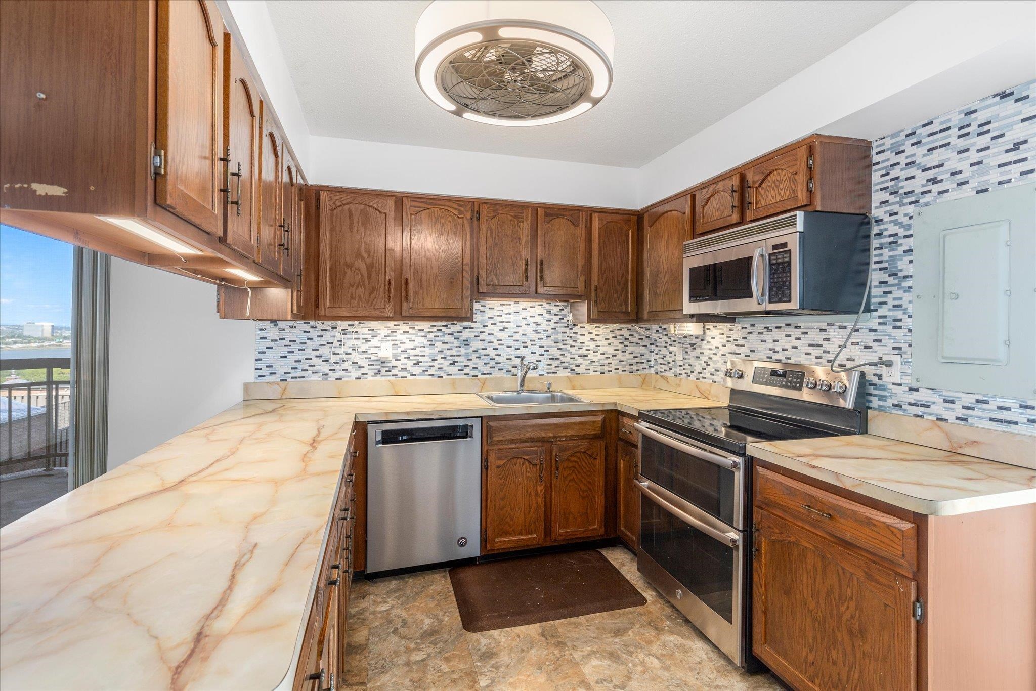 1705 Harmon Cove Tower, Unit 1705 Secaucus, NJ 07094 - Photo 7 of 49 a kitchen with stainless steel appliances granite countertop a sink stove and microwave