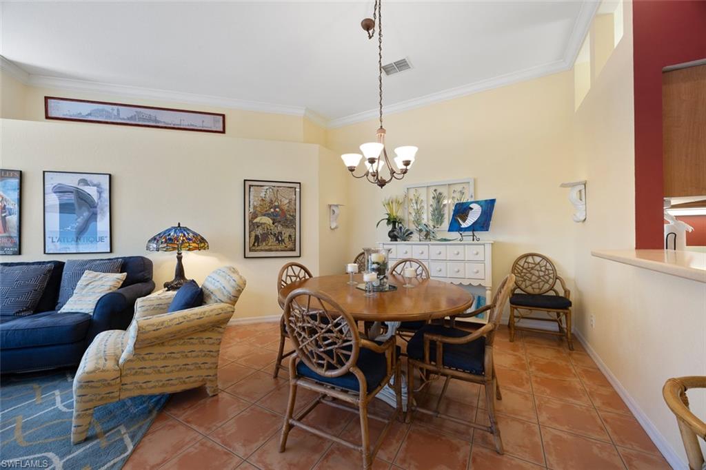 10305 Cape Roman Road, Unit 101 Estero, FL 34135 - Photo 9 of 27 Dining space with baseboards, ornamental molding, visible vents, and tile patterned floors