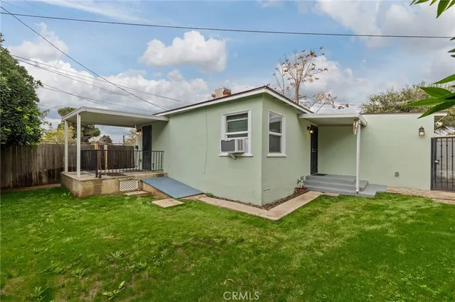 a view of a house with backyard and sitting area