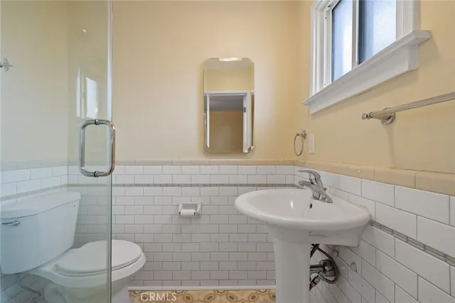 a bathroom with a sink toilet and a mirror
