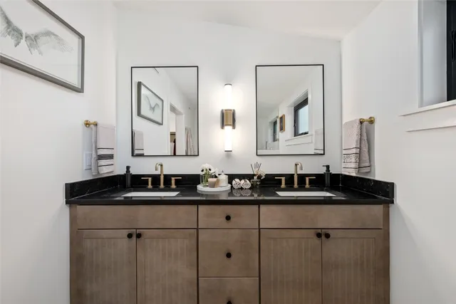 a bathroom with double sink and a mirror