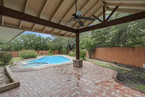 a view of a backyard with table and chairs under an umbrella