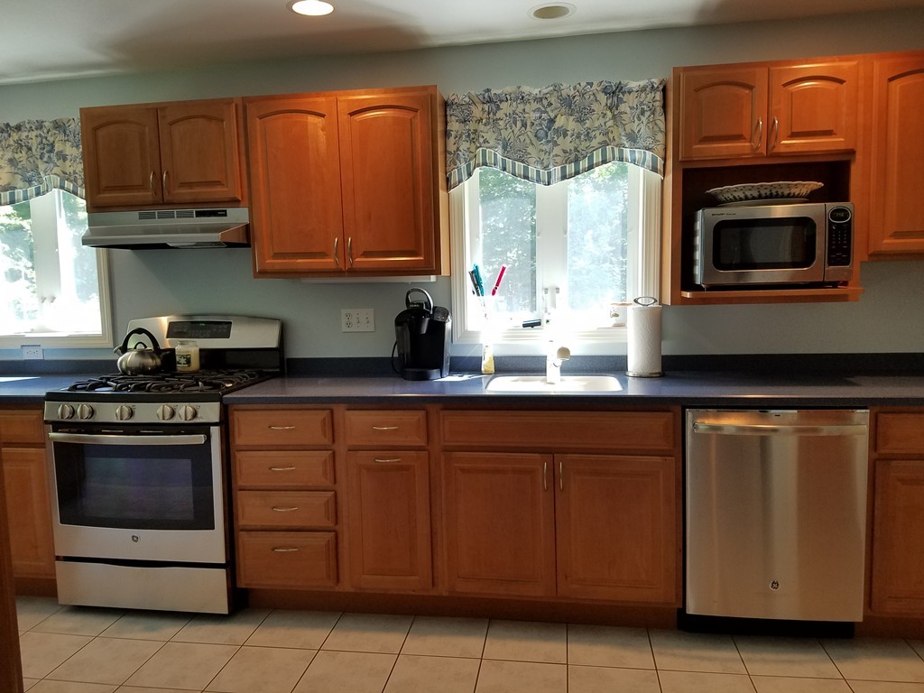 110 Hunt Road Chelmsford, MA 01824 - Photo 5 of 26 a kitchen with stainless steel appliances granite countertop a stove a microwave and a sink