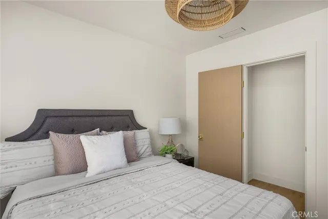 a bedroom with a large bed and a potted plant