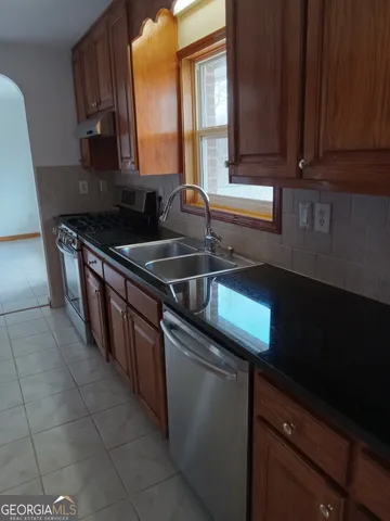 a kitchen with stainless steel appliances granite countertop a sink stove and cabinets