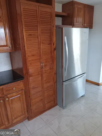 a view of kitchen with refrigerator and cabinet