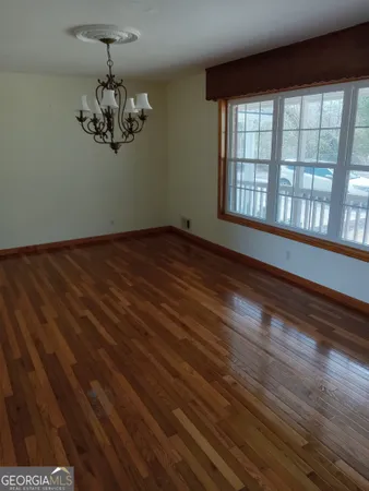 a view of a room with wooden floor and windows