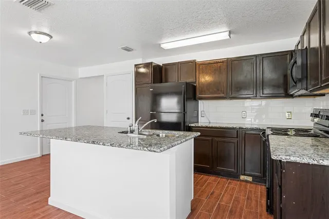 a kitchen with stainless steel appliances granite countertop a sink stove and microwave