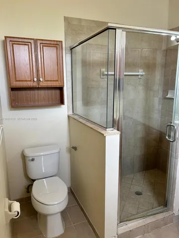 a bathroom with a toilet and a shower