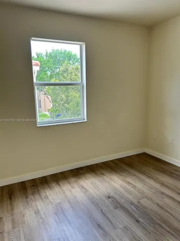 an empty room with wooden floor and a window