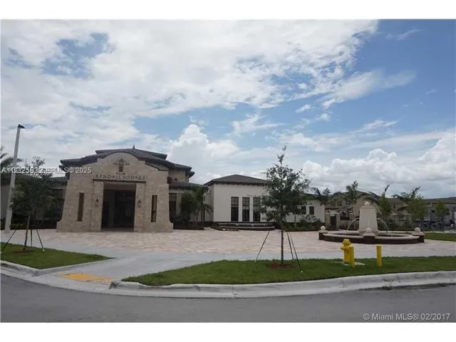 a view of a white house in front of a big yard