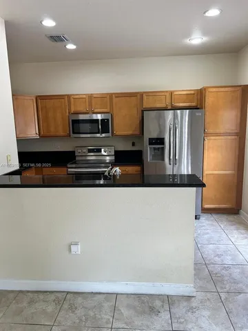 a kitchen with stainless steel appliances a refrigerator and a stove top oven