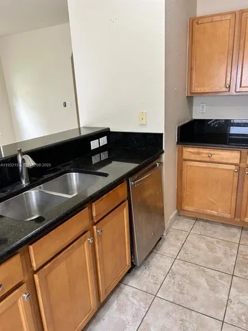 a kitchen with granite countertop a sink and a stove