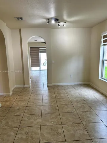 a view of a hallway with wooden floor and a living room