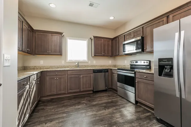a kitchen with stainless steel appliances granite countertop a refrigerator sink and microwave