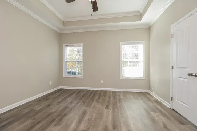 an empty room with wooden floor and windows