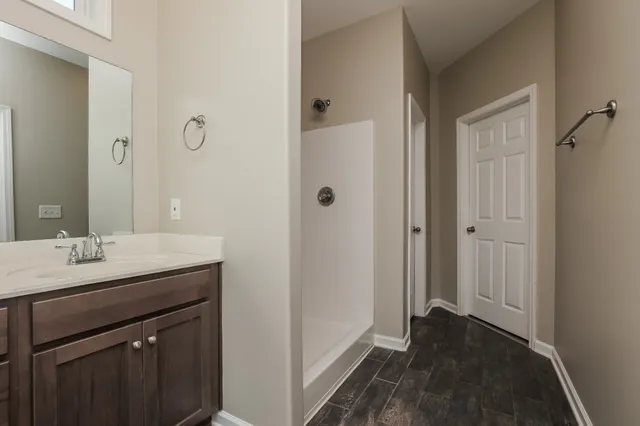 a bathroom with a sink a mirror and a shower
