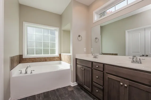 a bathroom with a tub sink and mirror