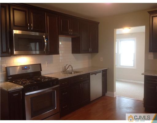23 Colton Road Edison, NJ 08817 - Photo 4 of 12 a kitchen with a sink a stove and cabinets