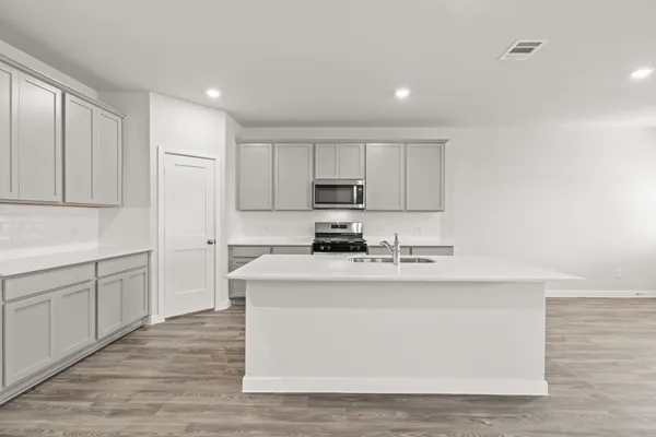 a kitchen with stainless steel appliances granite countertop a white stove top oven and white cabinets