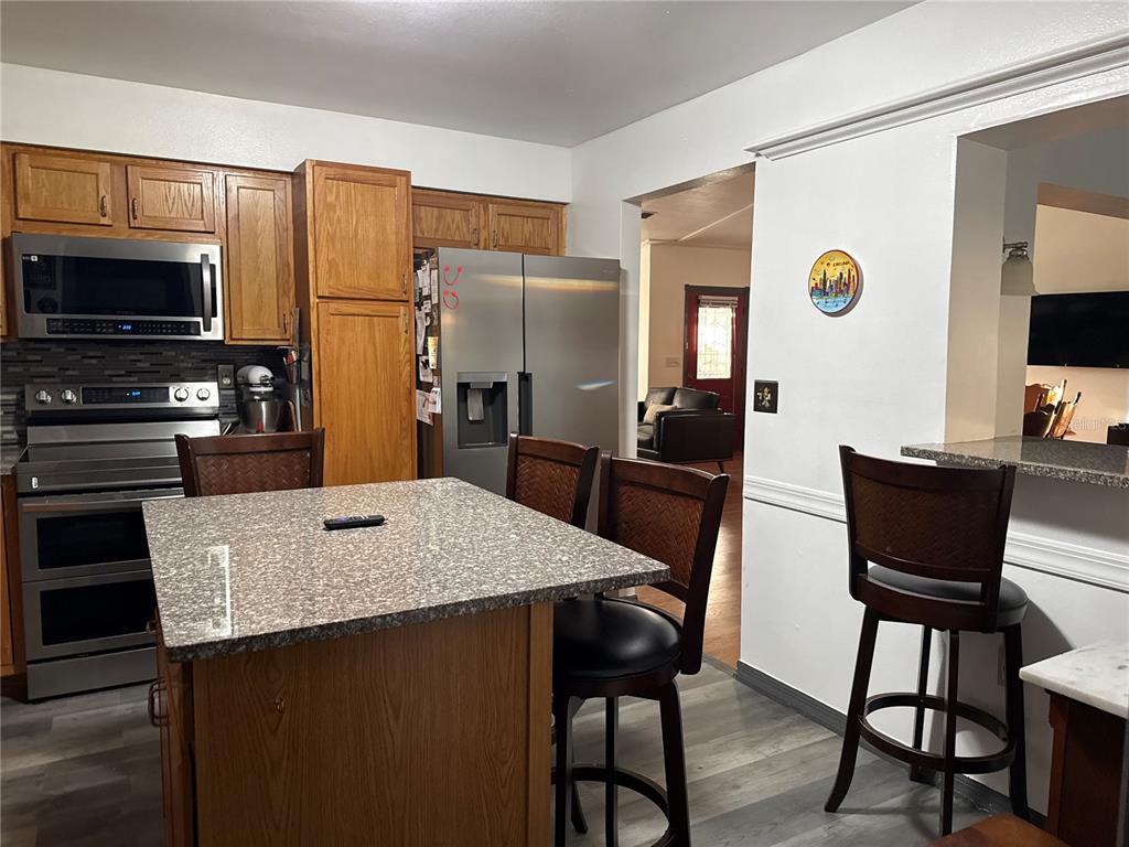 4560 Lamson Avenue Spring Hill, FL 34608 - Photo 21 of 41 a kitchen with stainless steel appliances wooden floor dining table and chairs