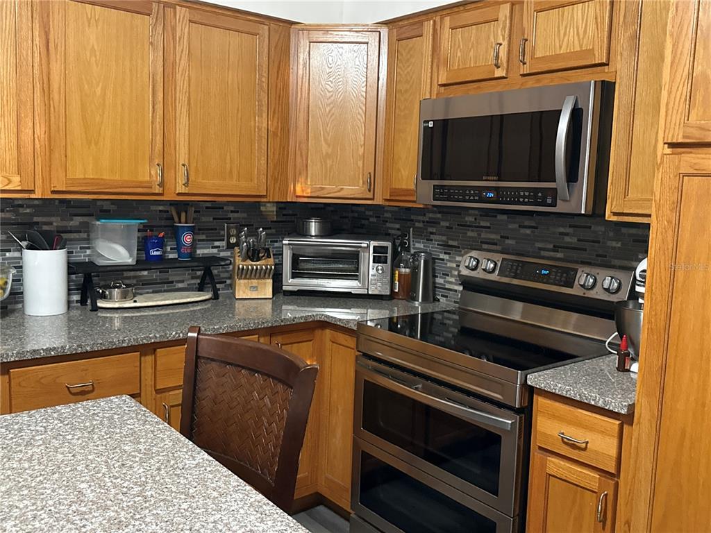 4560 Lamson Avenue Spring Hill, FL 34608 - Photo 22 of 41 a kitchen with stainless steel appliances granite countertop a stove microwave and cabinets