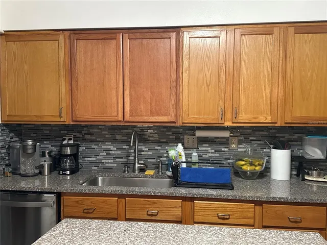 a kitchen with stainless steel appliances granite countertop a sink a stove cabinets and a counter top space