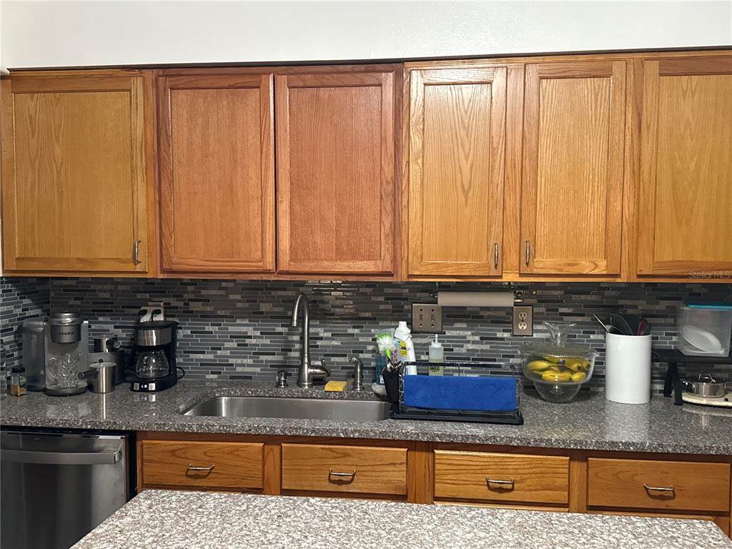 4560 Lamson Avenue Spring Hill, FL 34608 - Photo 23 of 41 a kitchen with stainless steel appliances granite countertop a sink a stove cabinets and a counter top space