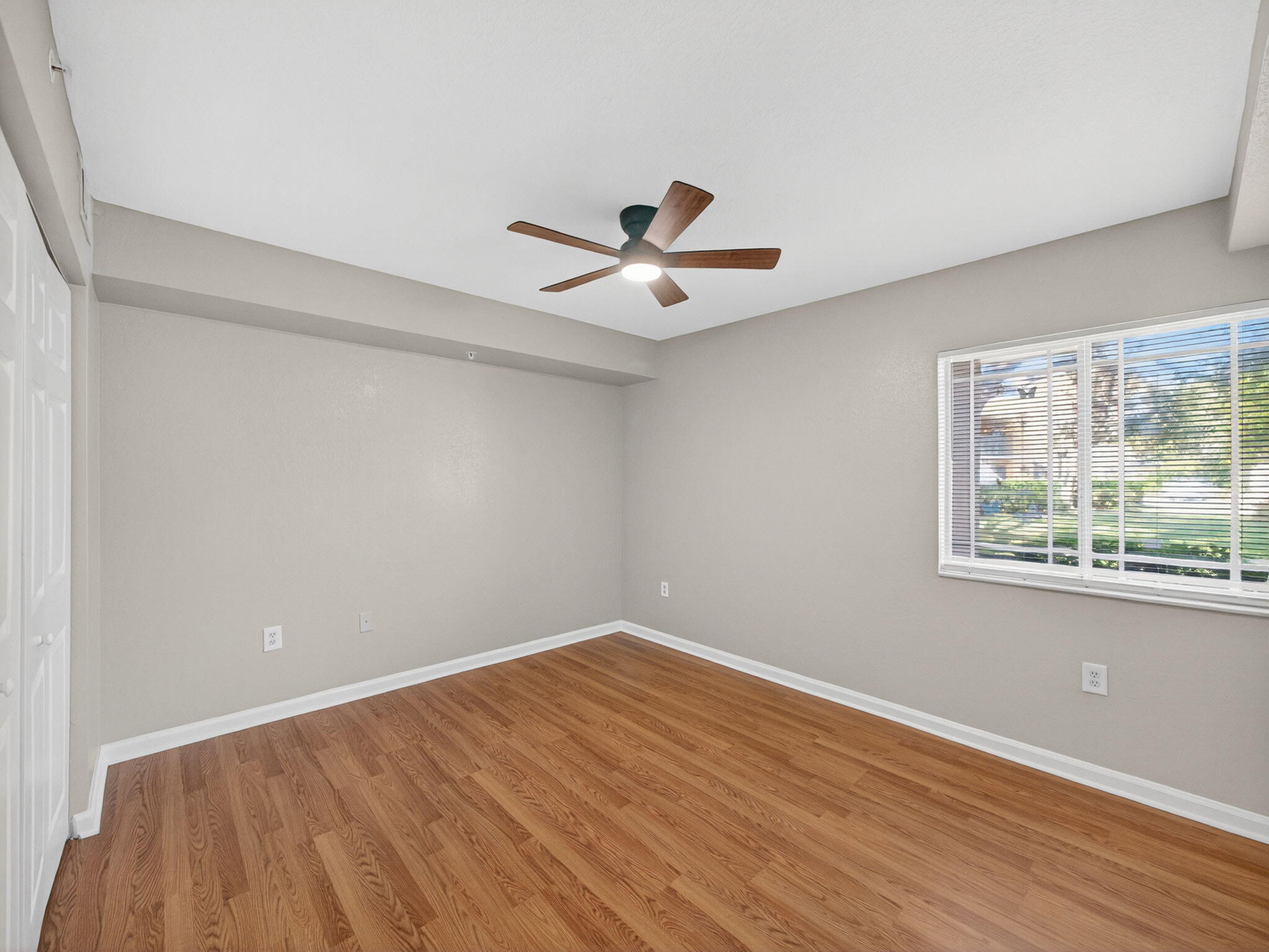 121 Southwest Palm Drive, Unit 107 Port St. Lucie, FL 34986 - Photo 12 of 15 an empty room with wooden floor and windows