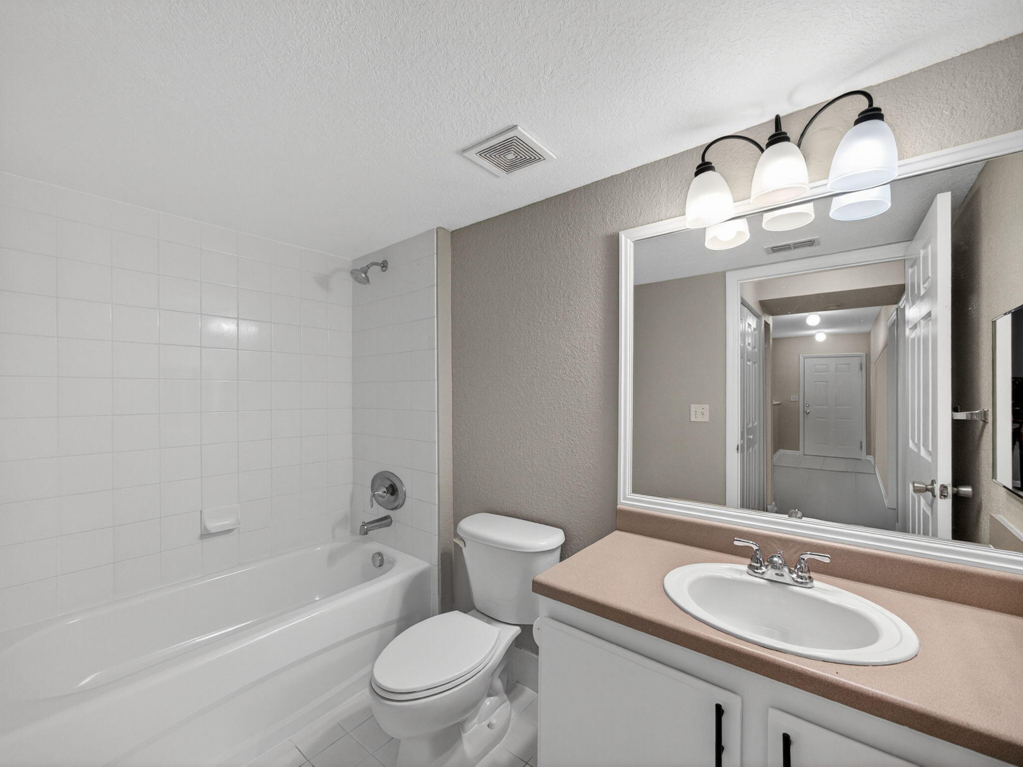 121 Southwest Palm Drive, Unit 107 Port St. Lucie, FL 34986 - Photo 13 of 15 a bathroom with a sink a toilet and shower