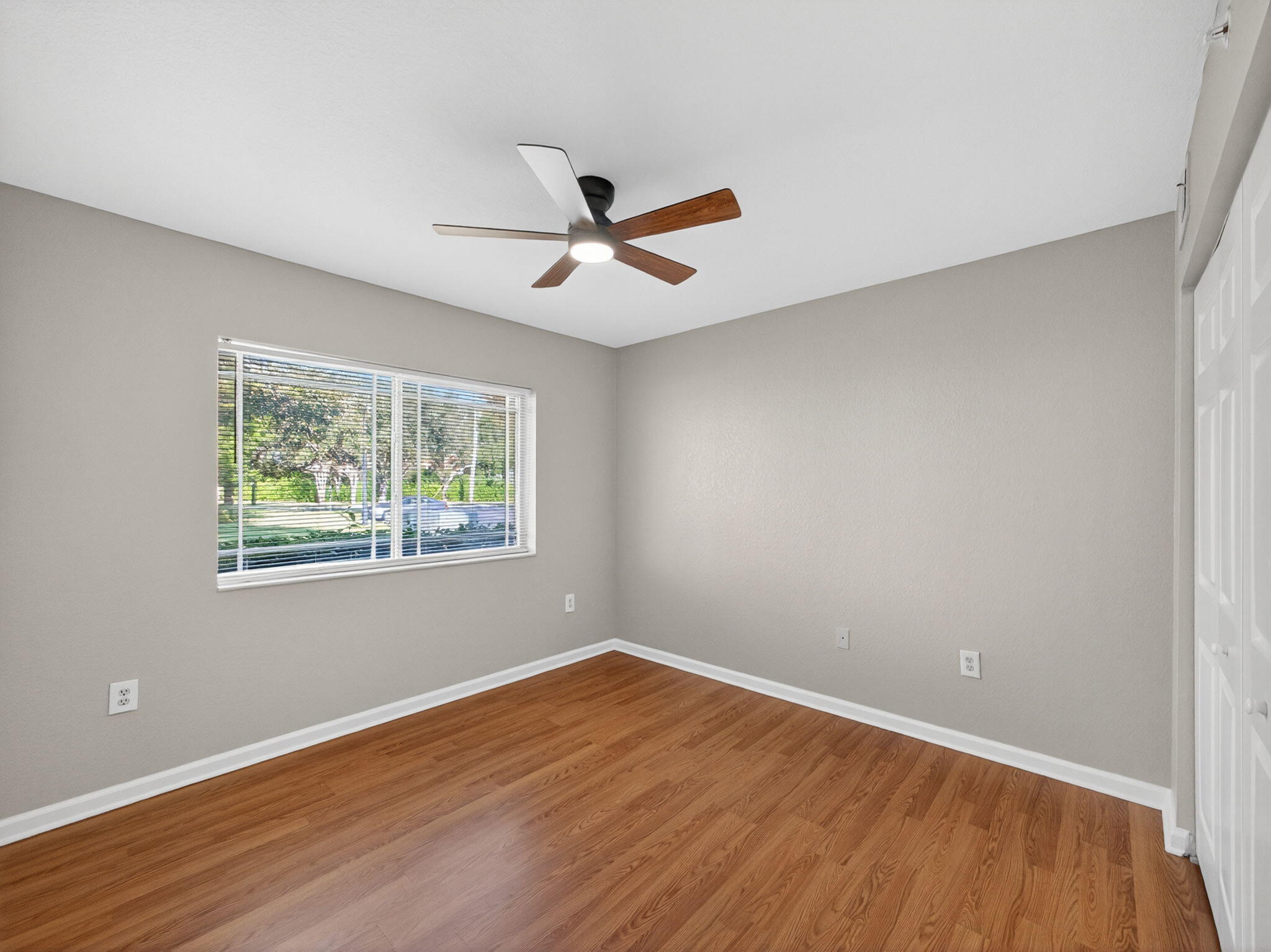 121 Southwest Palm Drive, Unit 107 Port St. Lucie, FL 34986 - Photo 14 of 15 a view of empty room with wooden floor and fan