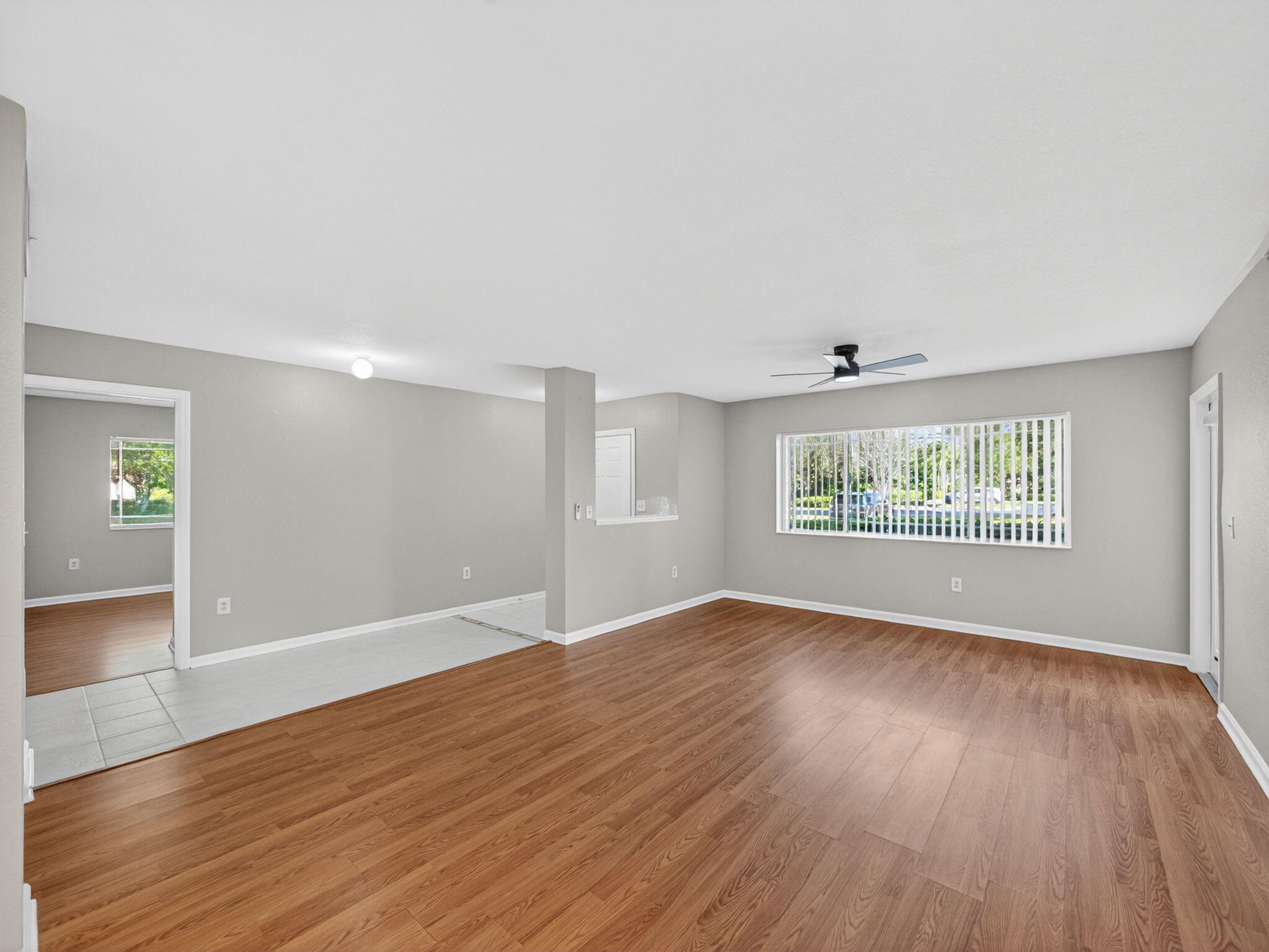 121 Southwest Palm Drive, Unit 107 Port St. Lucie, FL 34986 - Photo 4 of 15 an empty room with wooden floor and windows