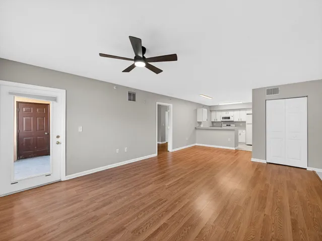 a view of empty room with wooden floor and window