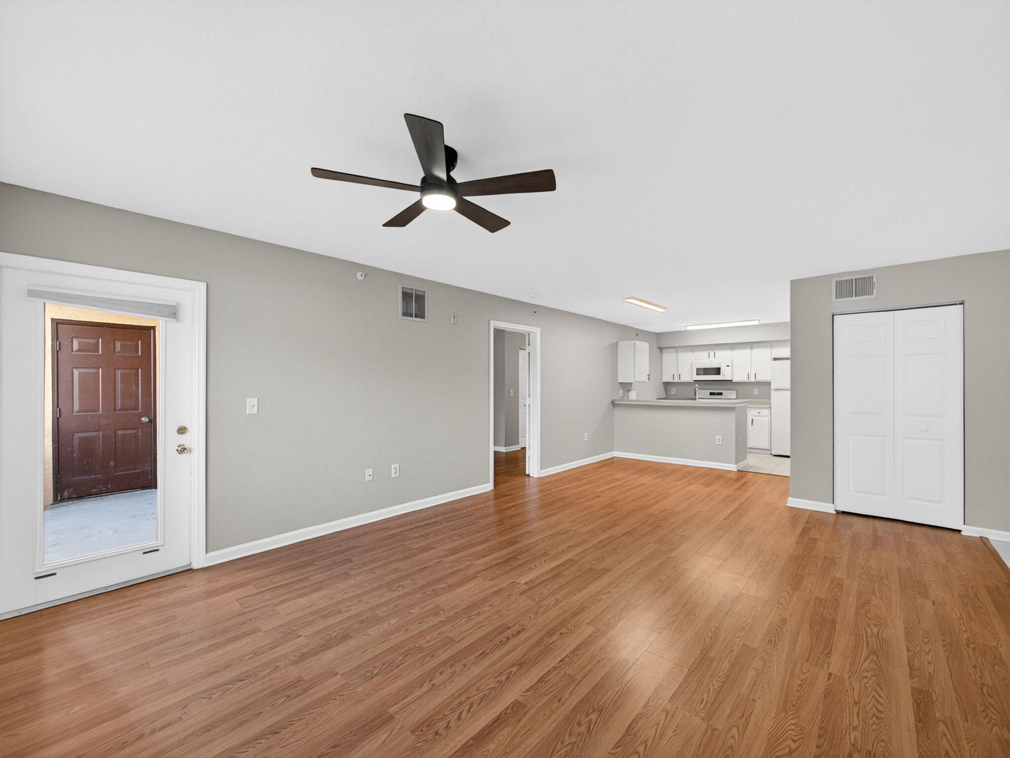 121 Southwest Palm Drive, Unit 107 Port St. Lucie, FL 34986 - Photo 5 of 15 a view of empty room with wooden floor and window