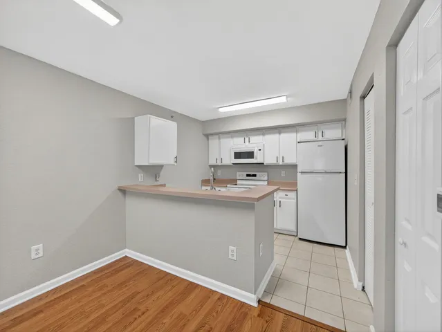 a kitchen with white cabinets and sink