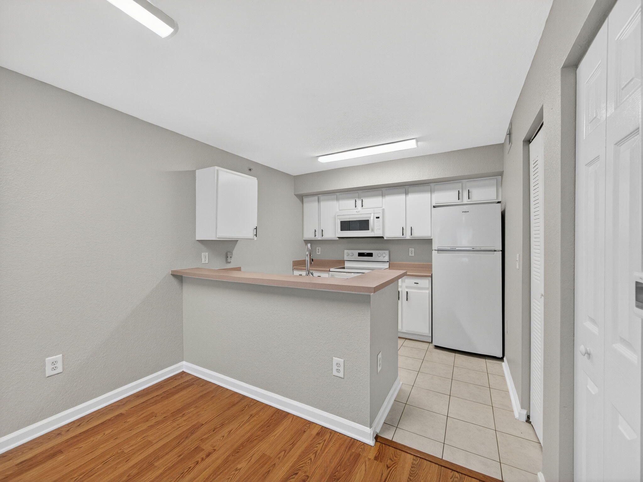 121 Southwest Palm Drive, Unit 107 Port St. Lucie, FL 34986 - Photo 6 of 15 a kitchen with white cabinets and sink