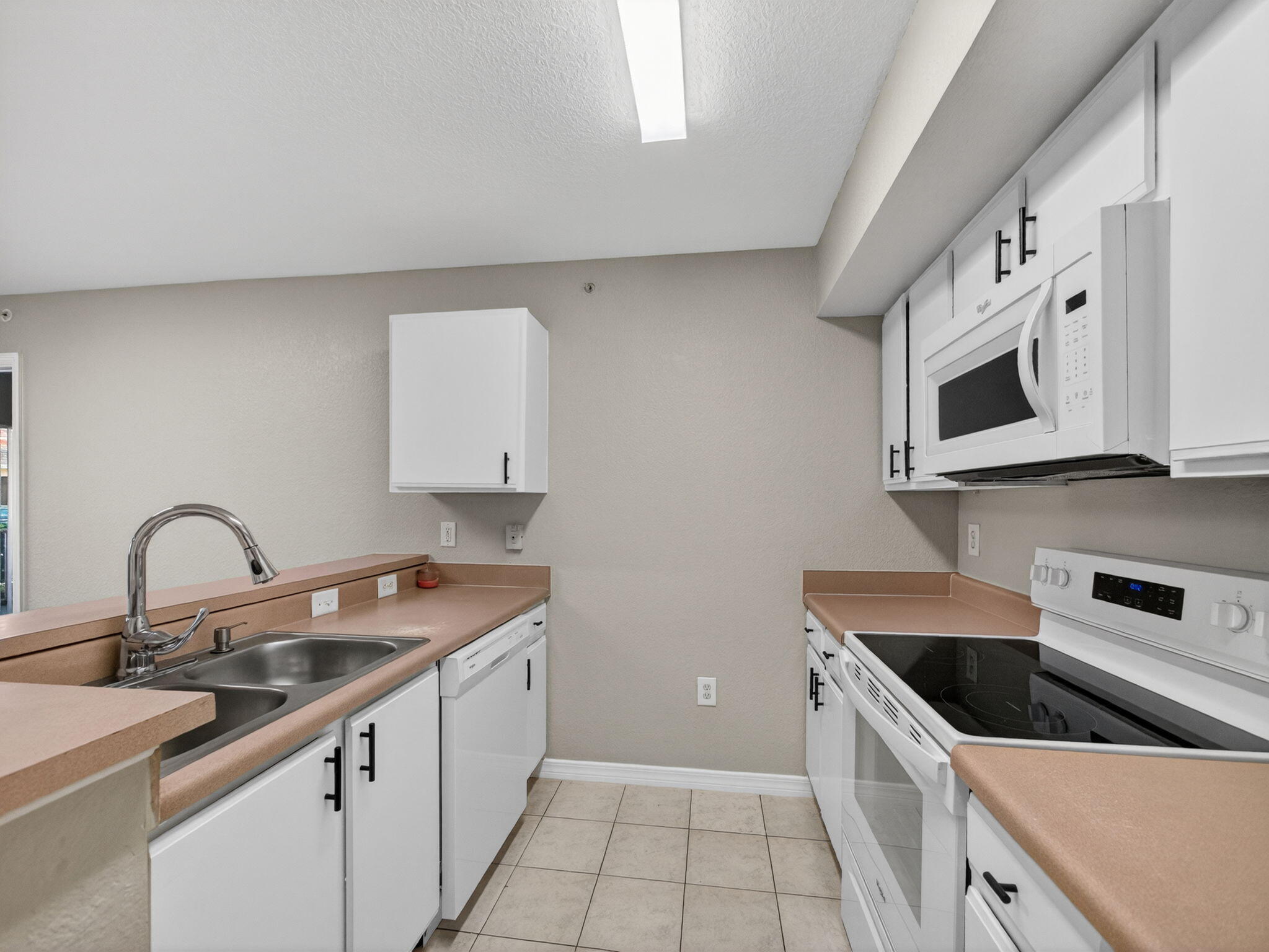 121 Southwest Palm Drive, Unit 107 Port St. Lucie, FL 34986 - Photo 7 of 15 a kitchen with granite countertop a sink and a stove top oven