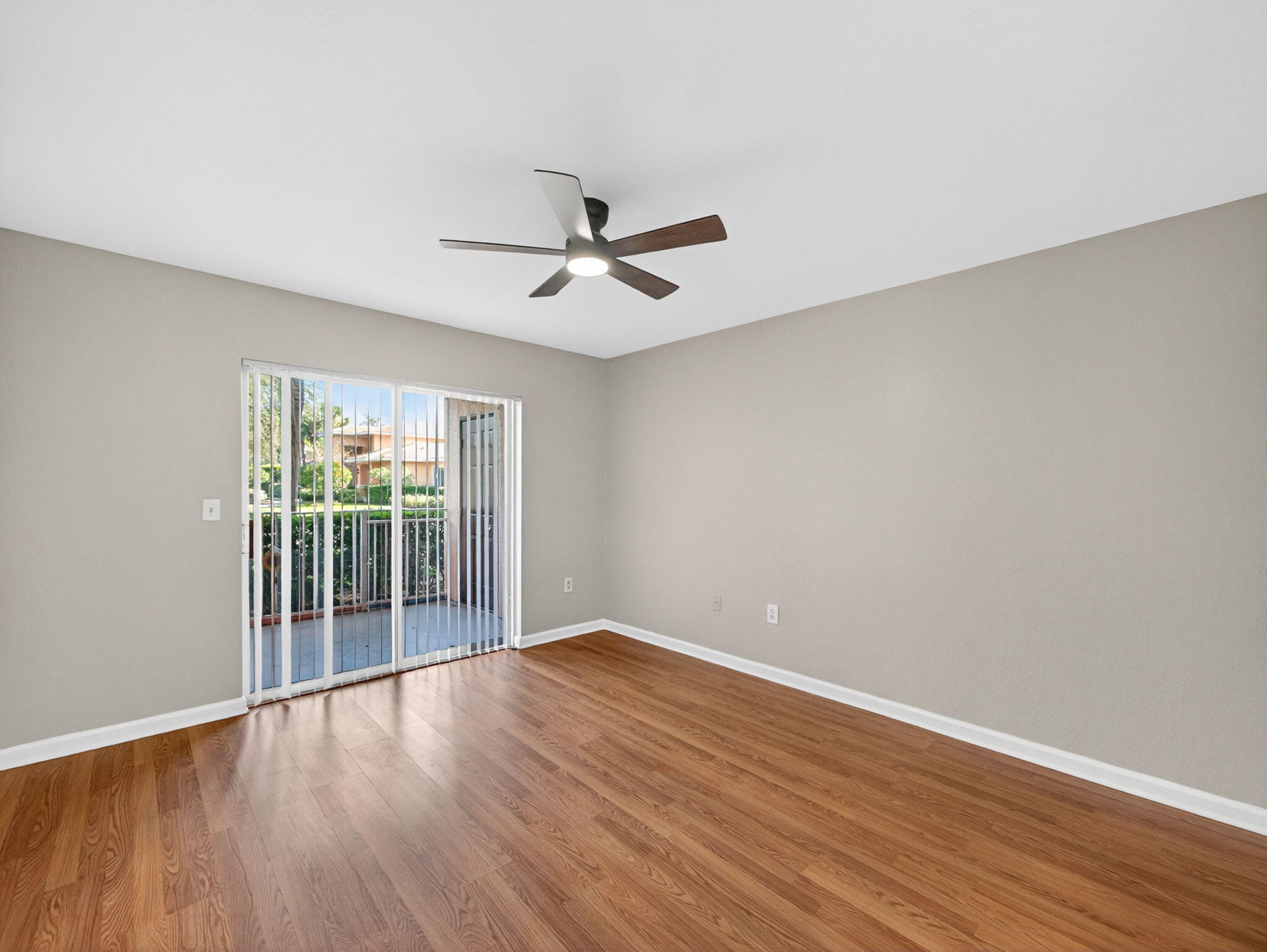 121 Southwest Palm Drive, Unit 107 Port St. Lucie, FL 34986 - Photo 8 of 15 a view of room with wooden floor and ceiling fan