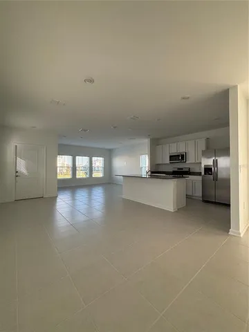 a view of a livingroom and a kitchen with furniture and window