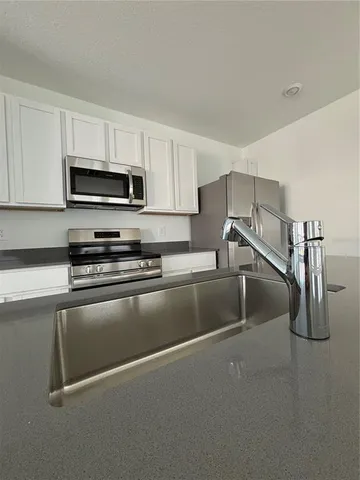 a kitchen with kitchen island a stove and a sink