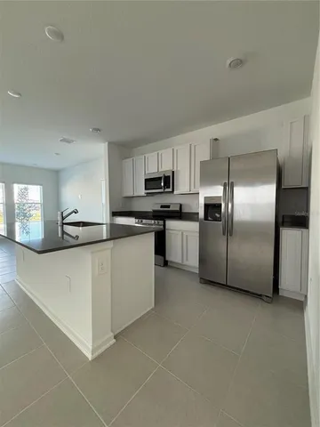 a kitchen with stainless steel appliances granite countertop a refrigerator a stove and a sink